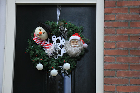 圣诞花环摄影照片_经典的圣诞花环，木门上装饰着