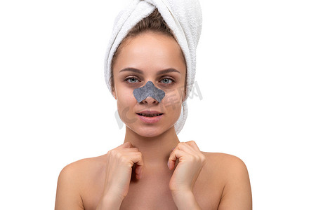一位年轻女子洗完澡后的肖像，脸上戴着布口罩，以去除鼻子毛孔中的黑头