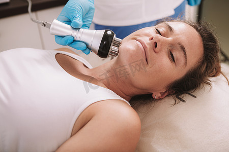 成熟女性在美容院接受射频提升治疗