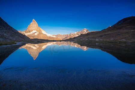 瑞士阿尔卑斯山宁静的日出时马特宏峰标志性的山脉和湖泊的反射