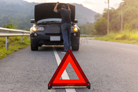 道路上的红色三角形标志警告车辆发生故障