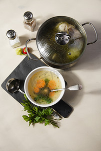 一个碗和一个锅，里面有新鲜的自制鸡肉汤和香料。