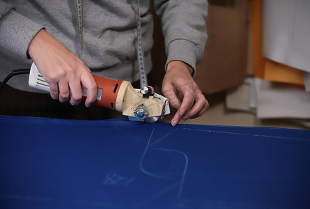 工人通过使用仪器绘制草图来裁剪布料。