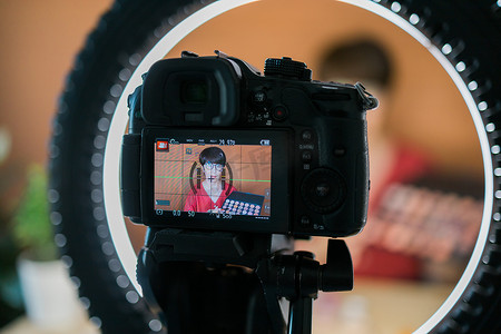 时影摄影照片_中年妇女在录制视频时用眼影、腮红调色板和刷子谈论化妆品。