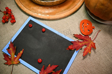 立秋广告摄影照片_顶视图黑板，上面有复制广告空间，旁边是秋枫叶和成熟的红色荚莲属植物浆果的树枝