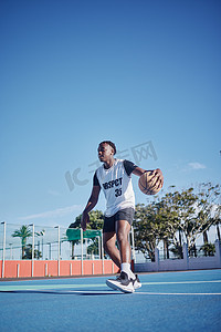 运动会幕布摄影照片_健身男子在运动场上打篮球。