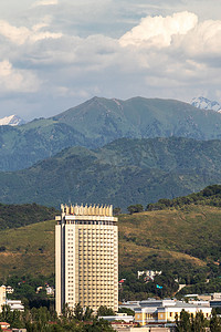 哈萨克斯坦国摄影照片_阿拉木图市 Medeu 区的垂直景观与 GATOB 剧院和哈萨克斯坦著名酒店在阿拉木图山脉的背景下