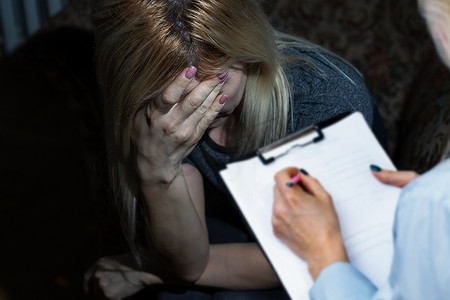 围围巾摄影照片_一个年轻漂亮的乌克兰女人和心理学家坐在一起哭