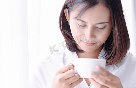 特写女人手拿着一杯热美式咖啡，选择