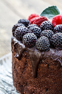 特写自制巧克力蛋糕，装饰着黑色和红色覆盆子