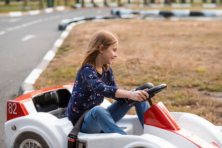 快乐的小女孩在公园里驾驶卡丁车