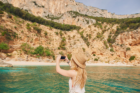 美丽的女人乘坐快艇前往天堂海滩岛拍照智能手机发现夏季冒险假期