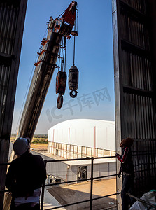 吊机摄影照片_工业厂房窗口的起重机吊机