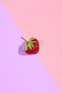 粉紫色背景上孤立的新鲜红草莓