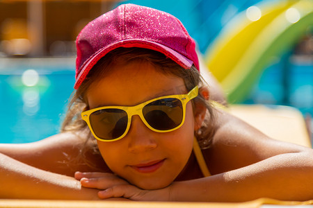 晒水摄影照片_孩子正在泳池边晒日光浴。