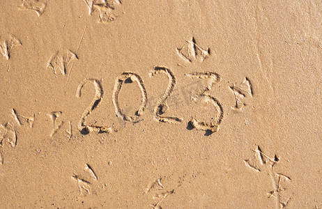 2023喜庆摄影照片_沙滩上的沙子上写着数字2023。