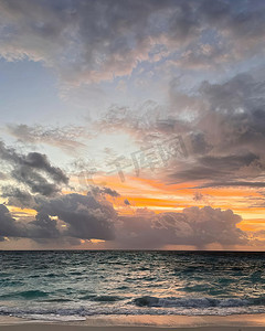 海面天空摄影照片_平静的海面，夕阳的天空和阳光透过云层。