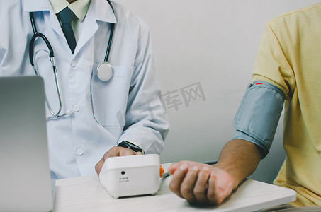 医生测量一位老年男性患者的血压。