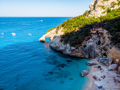 Golfo di Orosei Sardina，从上面看，令人惊叹的鸟瞰海滩充满了遮阳伞，人们在碧绿的海水中晒日光浴和游泳。 