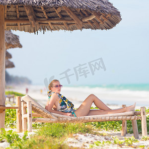 在热带海滩上晒日光浴的女人。