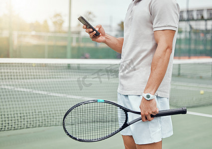 未知的混血网球运动员在球场比赛休息期间使用手机发短信。