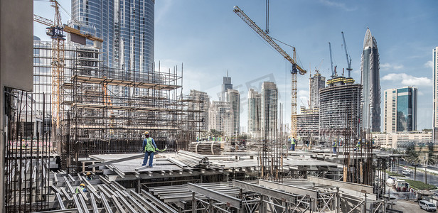 迪拜摄影照片_在现代建筑工地工作的劳工在迪拜工作。
