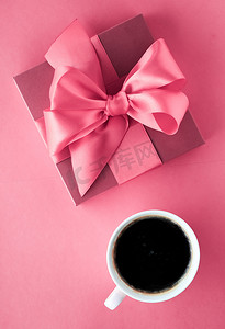 粉色背景的豪华礼盒和咖啡杯，平铺设计，带来浪漫假日早晨的惊喜