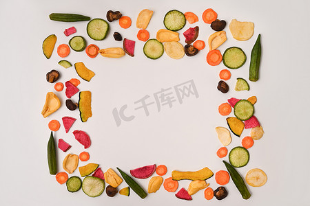 彩色混合蔬菜片，配以秋葵、胡萝卜、南瓜、甜菜根和香菇，背景为白色。