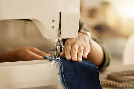 缝纫机特写摄影照片_使用缝纫机的裁缝的手的特写镜头。