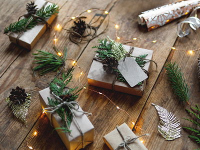圣诞礼物用牛皮纸包裹，用天然杉树和崖柏树枝作为装饰。