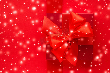 冬季节日礼物和红色背景下的发光雪，圣诞礼物惊喜