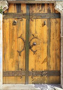横板摄影照片_古董木门，配有锻造把手、铆钉和横档。