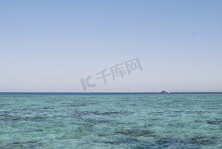 美丽清澈的绿松石海水表面的照片特写，海景背景上有波纹低波，水平图片