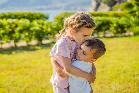 两个可爱的小孩子互相拥抱和亲吻的肖像，童年概念中的爱情友谊，永远最好的朋友