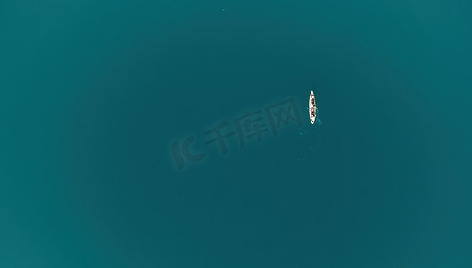 安静平静平静摄影照片_一个家庭在平静的蓝色大海中划皮划艇的空中俯视图。