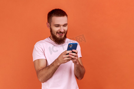 沉迷手机摄影照片_男人用快乐的表情使用手机，沉迷于智能手机，在社交网络中发短信。