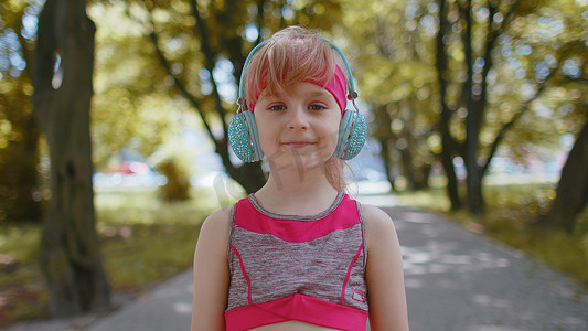 运动运动员女童训练肖像，戴耳机听最喜欢的音乐歌曲