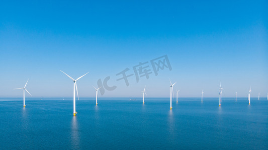 电商展台绿色摄影照片_海洋中的风车公园，无人机鸟瞰产生绿色能源电力的风车涡轮机，荷兰海上隔离的风车