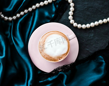 一杯卡布奇诺早餐，配有缎子和珍珠珠宝背景，巴黎咖啡馆的有机咖啡和无乳糖牛奶，适合豪华复古度假品牌
