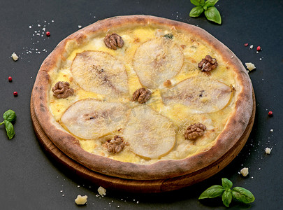 水果煮熟摄影照片_水果自制甜梨披萨配奶酪和坚果，意大利乡村风味食品配糕点面团，顶视图，复制空间