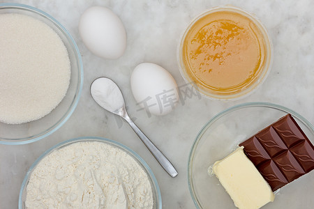 蛋糕蜂蜜摄影照片_糖、面粉、鸡蛋、小苏打、黄油、巧克力和蜂蜜