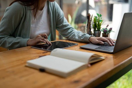 亚洲女性在记事本和数字平板电脑上做笔记，在室内笔记本电脑上工作或学习 — 教育课程或培训、研讨会、在线教育概念