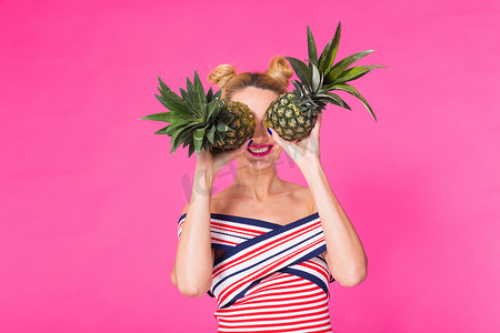 粉红色背景中带菠萝的时尚肖像滑稽女人