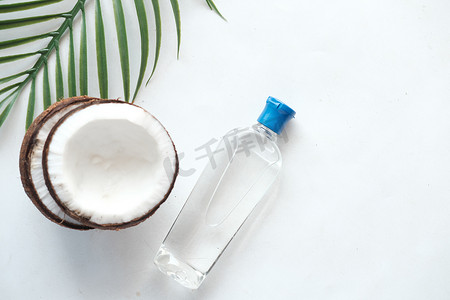 白色背景中的新鲜椰子片和一瓶油