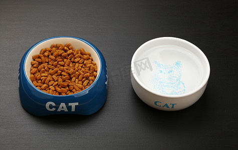 黑地板碗里的干猫粮和水