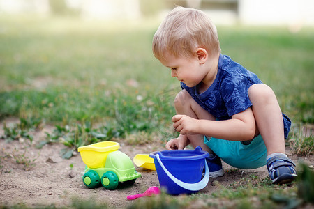 玩沙子和塑料彩色玩具的男孩