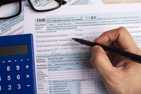 个人所得税摄影照片_填写税表 1040。桌上的美国个人所得税申报表。