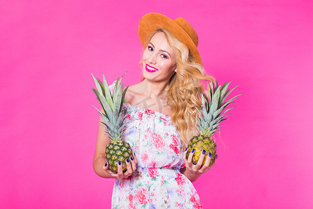 粉红色背景中带菠萝和复制空间的时尚肖像年轻美女
