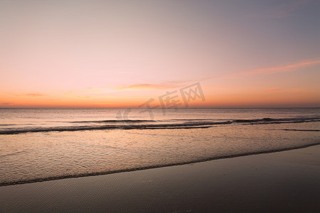 平静的海面与夕阳的天空与云。