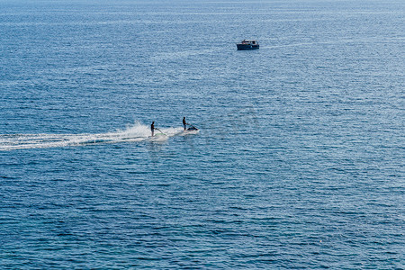 两个人在船的背景下在海上骑水上自行车